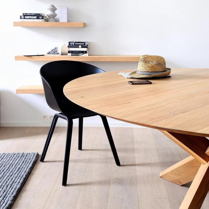 Circle Oak Dining Table by Ethnicraft, showing side view of dining table with chair in the live shot.