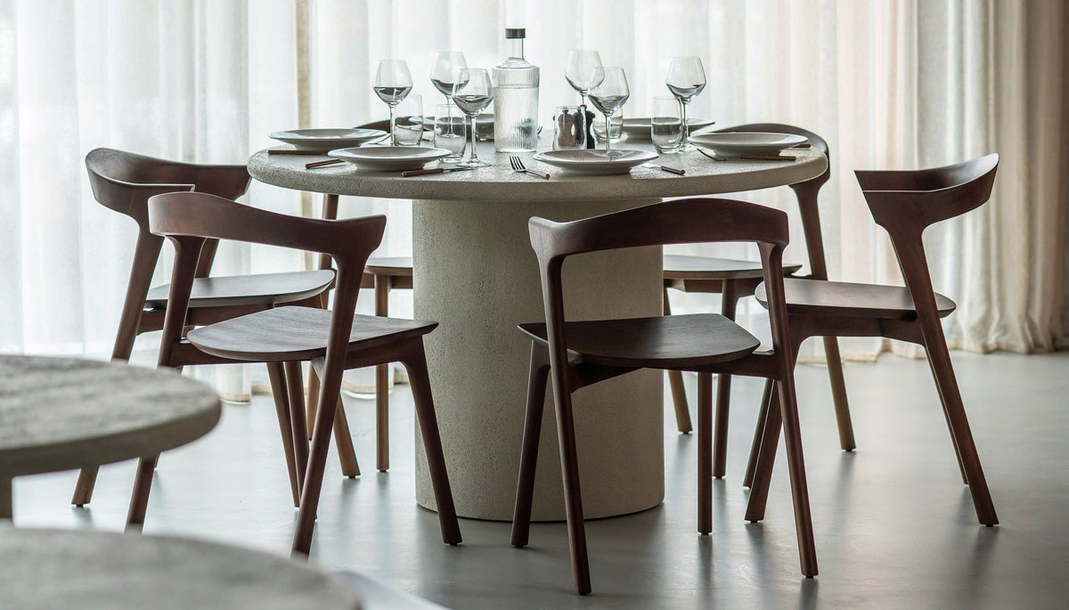 Round Ethnicraft Elements dining table set for six with dark oak Bok dining chairs in a bright modern dining room