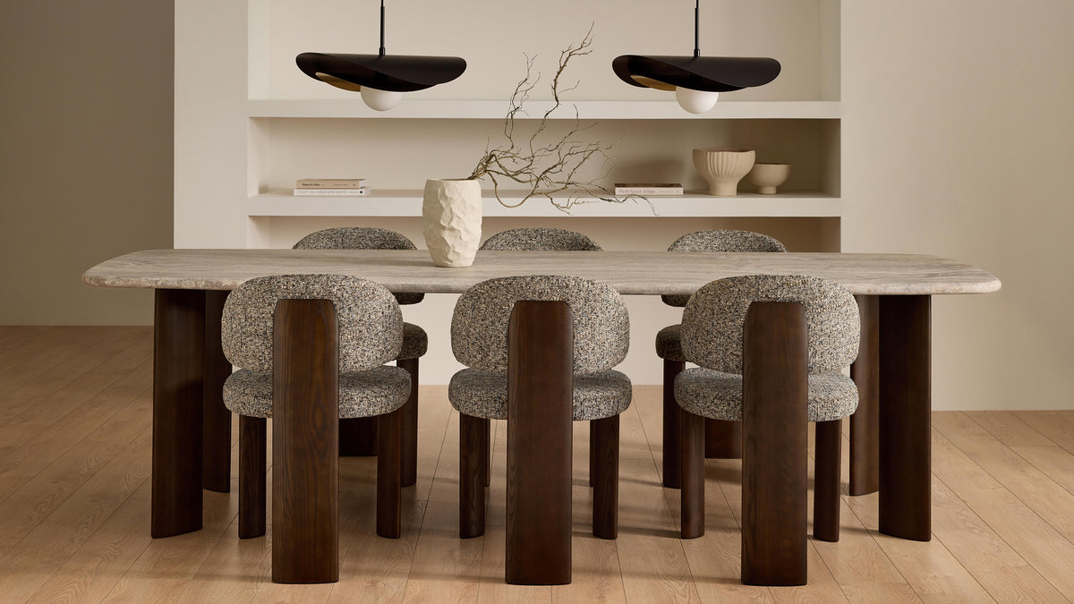 Mobital Sake dining chairs in cream boucle around a stone-topped dining table in a modern room