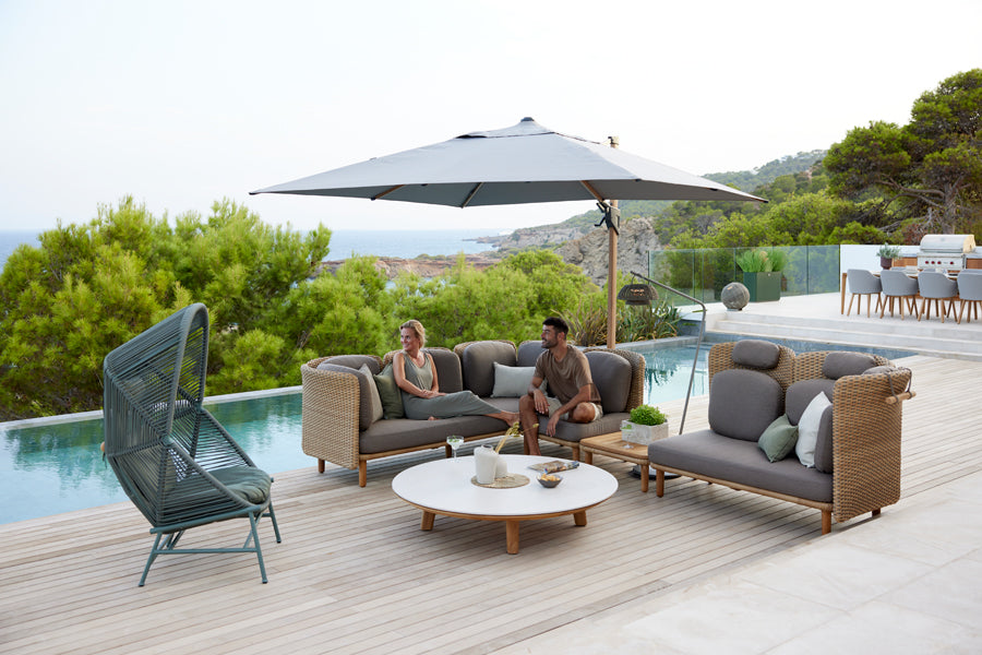Arch Coffee Table by Cane-Line, showing arch coffee table in live shot.