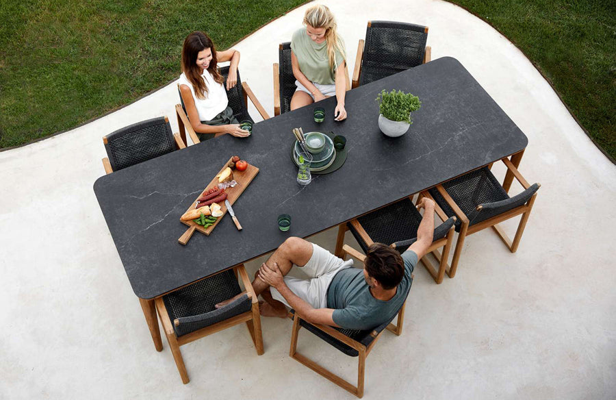 Aspect Outdoor Dining Table by Cane-Line, showing aspect outdoor dining table with chairs in live shot.