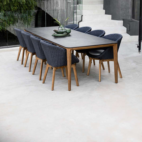 Aspect Outdoor Dining Table by Cane-Line, showing aspect outdoor dining table with chairs in live shot.