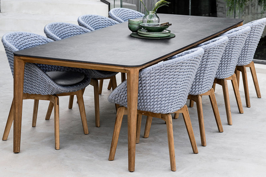 Aspect Outdoor Dining Table by Cane-Line, showing aspect outdoor dining table with chairs in live shot.