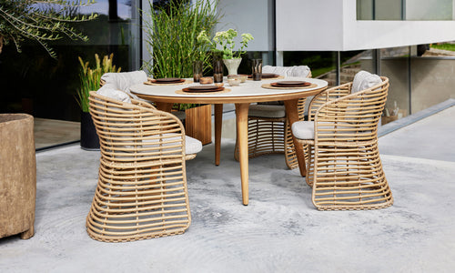 Basket Dining Chair by Cane-Line, showing baket dining chairs in live shot.