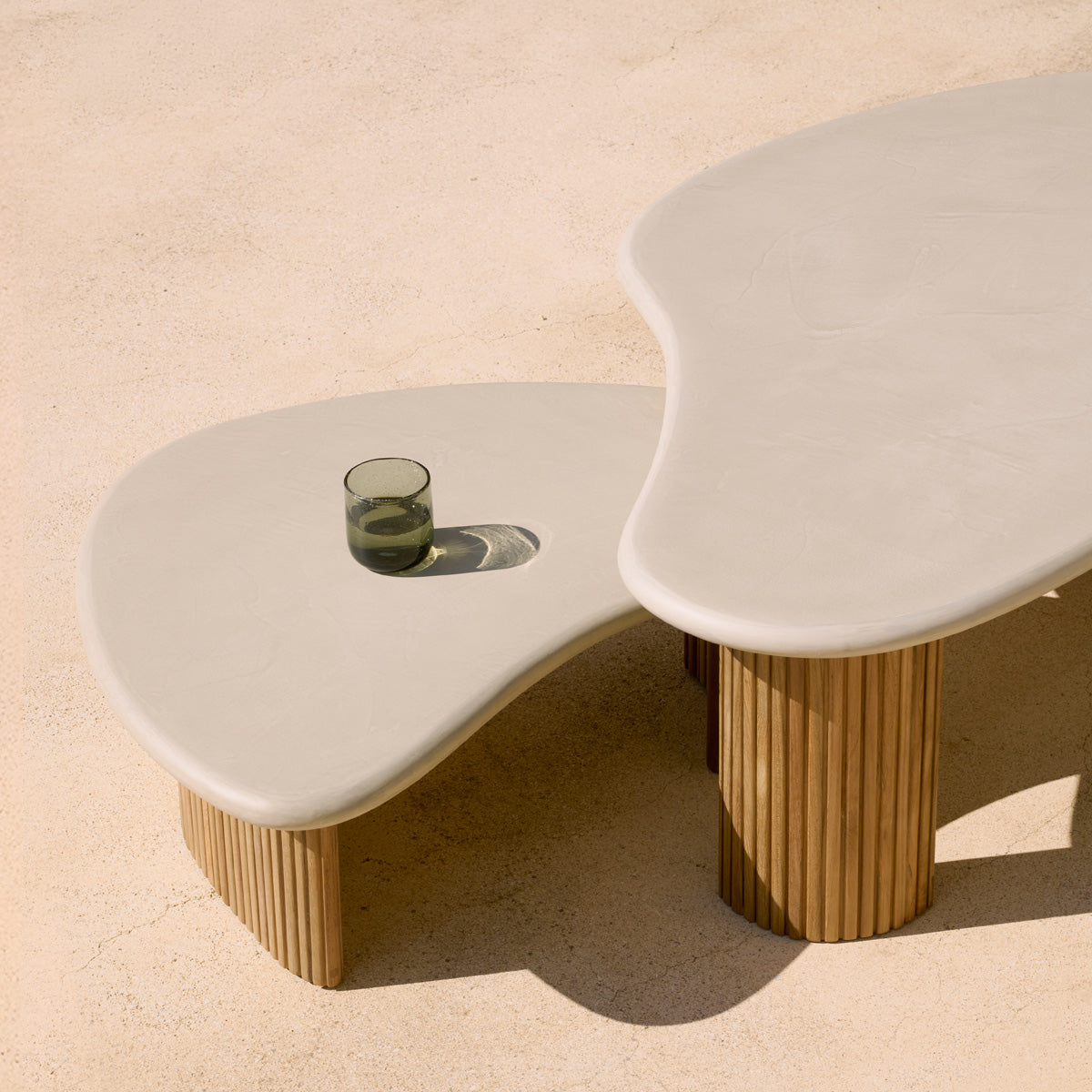 Boomerang Outdoor Coffee Table by Ethnicraft, showing closeup view of boomerang outdoor coffee tables in live shot.