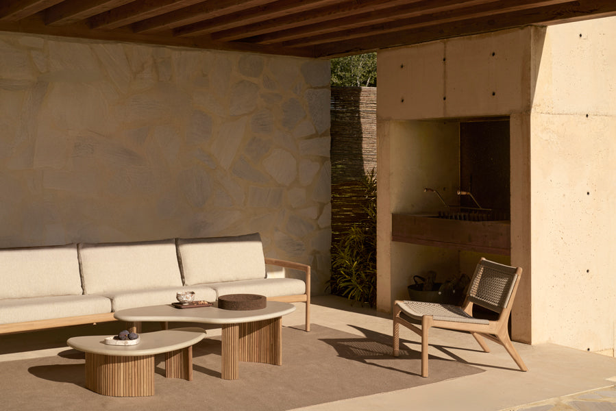 Boomerang Outdoor Coffee Table by Ethnicraft, showing boomerang outdoor coffee tables in live shot.