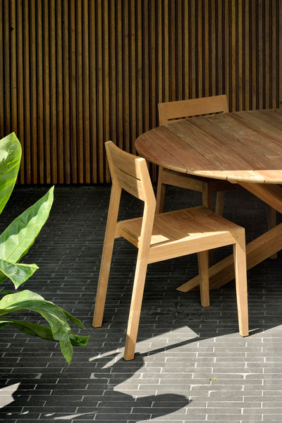 Circle Dining Table by Ethnicraft, showing closeup view of circle dining table with chairs in the live shot.