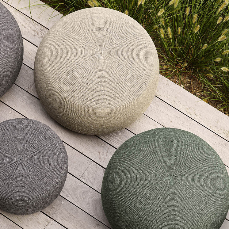 Circle Footstool by Cane-Line, showing closeup view of circle footstools in live shot.