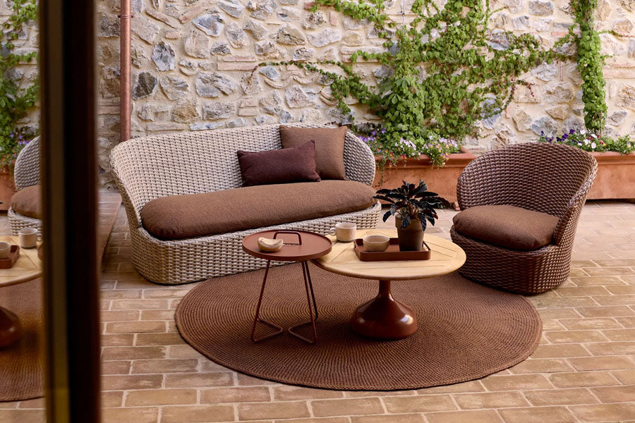 Coast Lounge Chair with Swivel by Cane-Line, showing coast lounge chair with swivel in live shot.