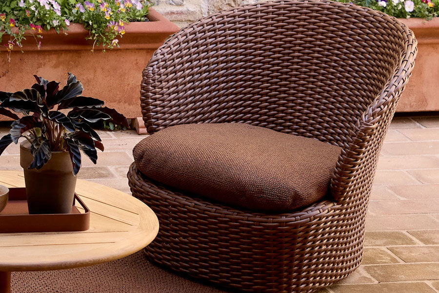 Coast Lounge Chair with Swivel by Cane-Line, showing coast lounge chair with swivel in live shot.
