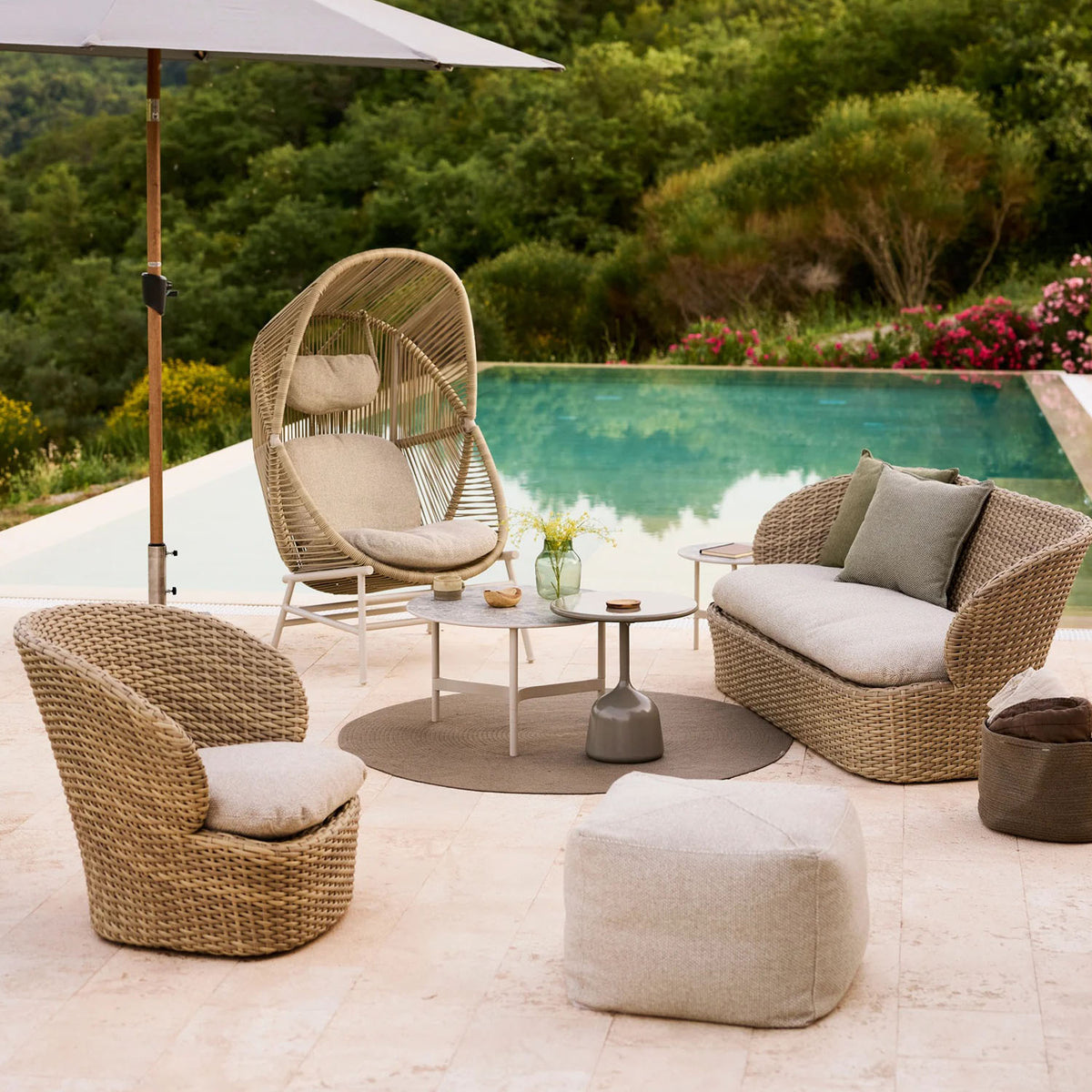 Coast Lounge Chair with Swivel by Cane-Line, showing coast lounge chair with swivel in live shot.