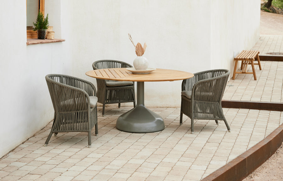 Derby Arm Chair by Cane-Line, showing derby arm chairs in live shot.