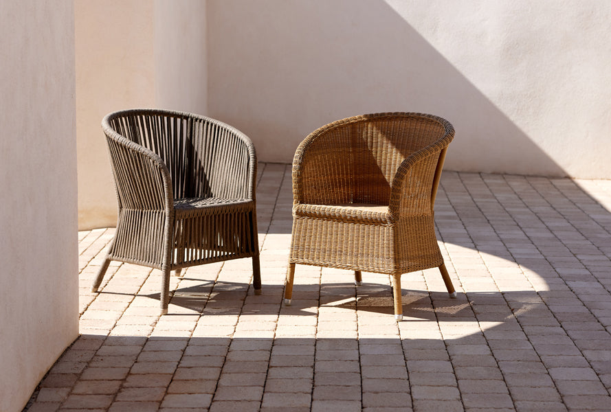 Derby Arm Chair by Cane-Line, showing derby arm chairs in live shot.