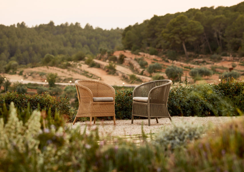 Derby Arm Chair by Cane-Line, showing derby arm chairs in live shot.