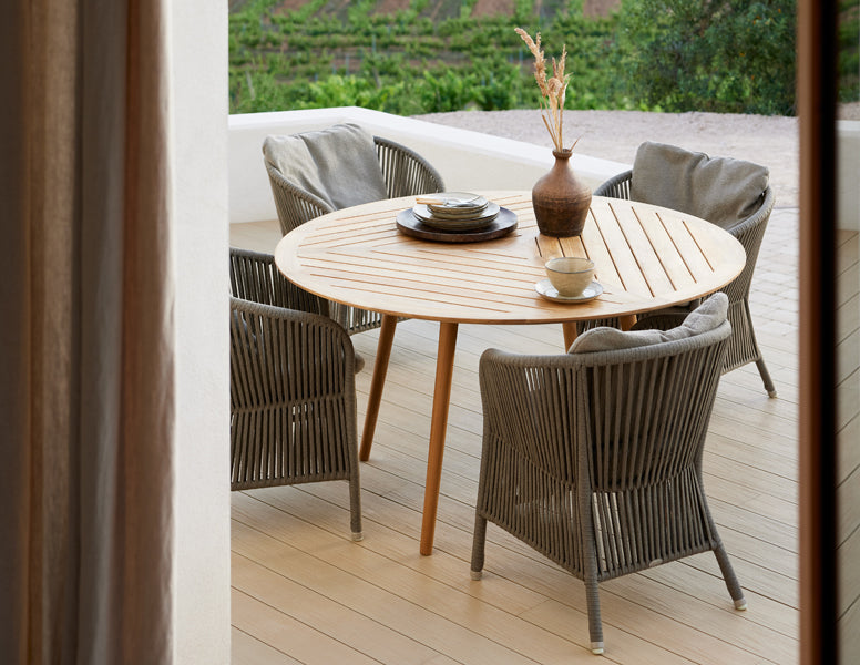 Derby Arm Chair by Cane-Line, showing derby arm chairs in live shot.