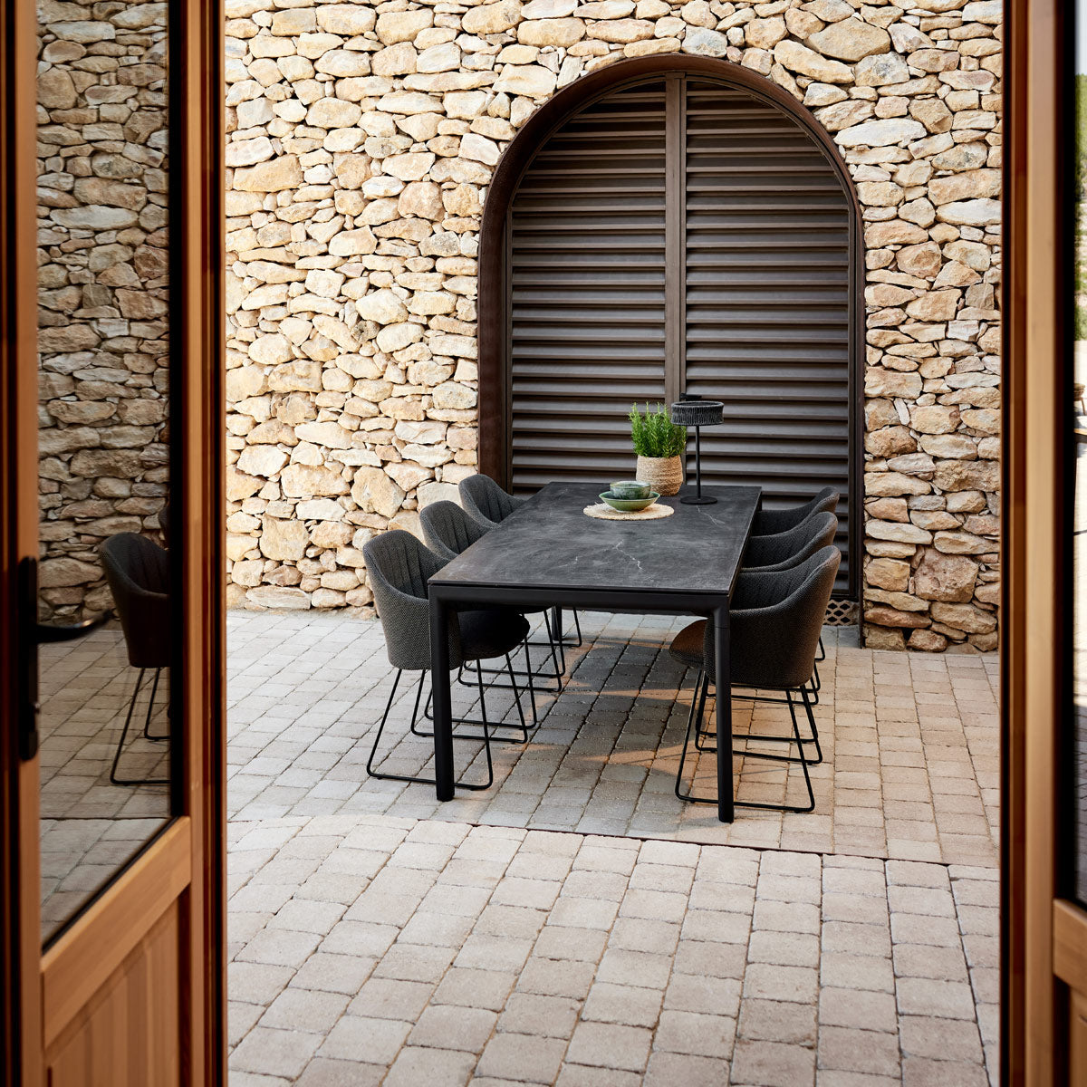 Drop Dining Table by Cane-Line, showing drop dining table in live shot.