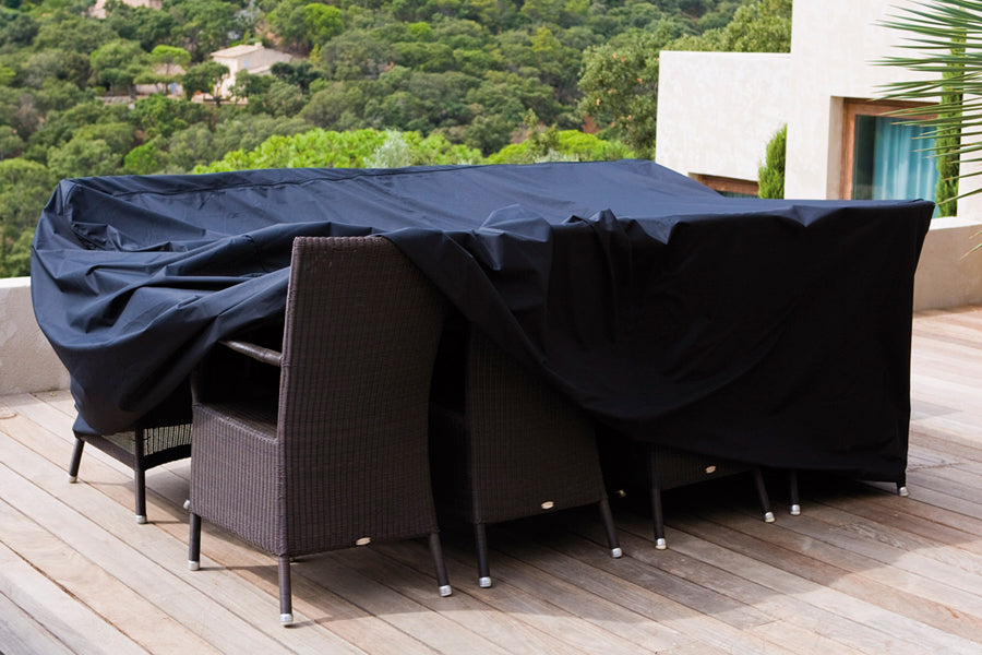 Edge Dining Table with Extension Leaves by Cane-Line, showing cover for edge dining table with extension leaves in live shot.