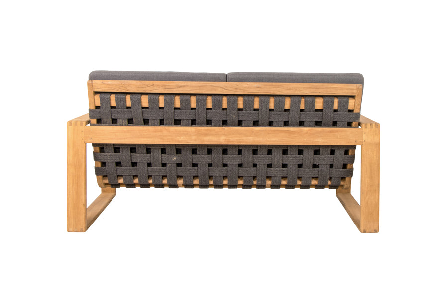 Endless Soft 2-Seater Sofa by Cane-Line, showing back view of endless soft 2-seater sofa in dark grey soft rope/teak/grey airtouch cushion set.