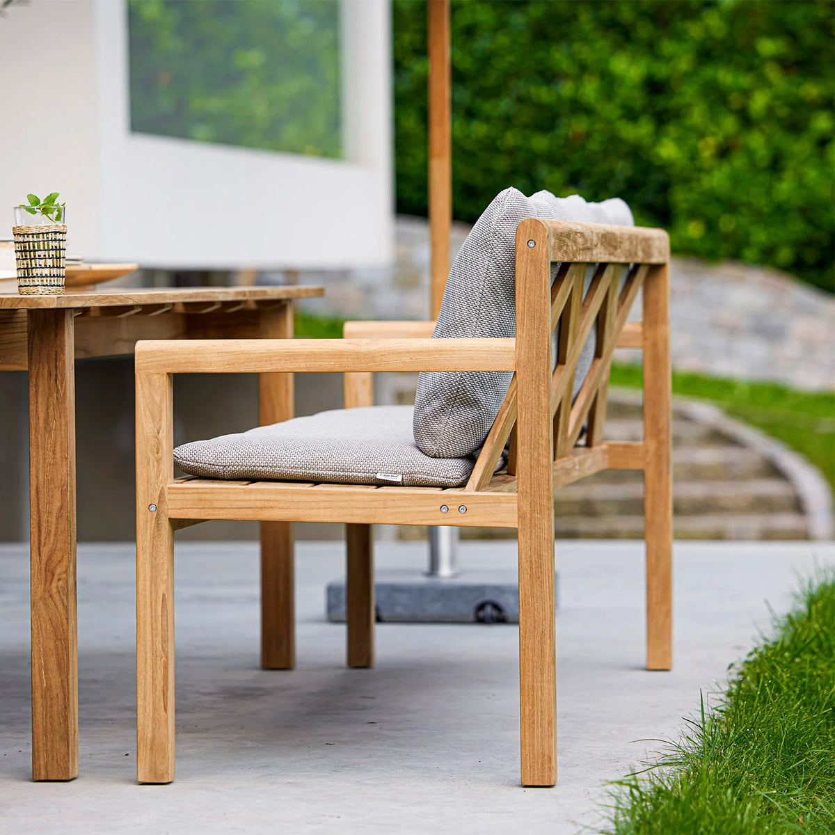 Grace Bench by Cane-Line, showing grace bench in live shot.