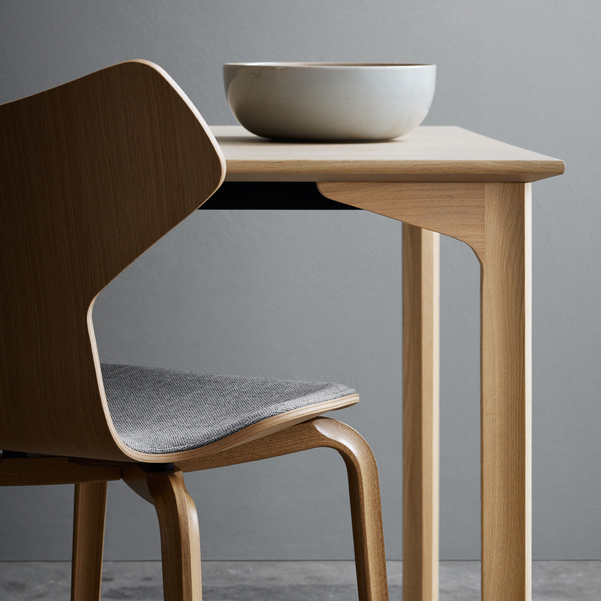 Grand Prix Front Upholstery Wooden Legs Chair by Fritz Hansen, showing closeup view of grand prix front upholstery wooden legs chair in live shot.