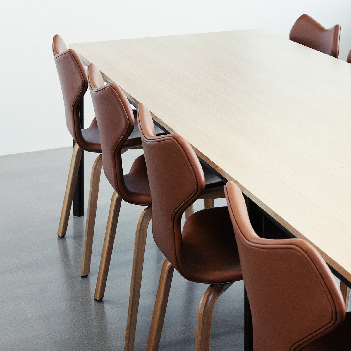 Grand Prix Full Upholstery Wooden Legs Chair by Fritz Hansen, showing closeup view of grand prix full upholstery wooden legs chairs in live shot.