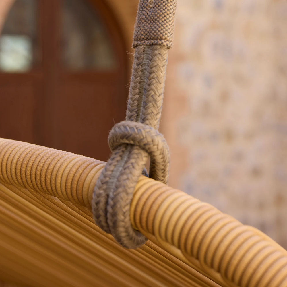 Hive 2-Seater Hanging Sofa With Rope by Cane-Line, showing closeup view of hive 2-seater hanging sofa with rope in live shot.