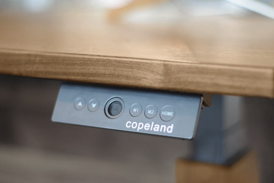 Invigo 30" x 60" Sit-Stand Rectangle Desk with Cutout Wire Pass Grommet (Right) by Copeland Furniture, showing closeup view of invigo 30" x 60" sit-stand rectangle desk with cutout wire pass grommet (right) in live shot