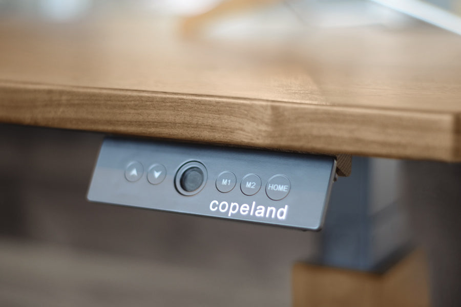 Invigo 30" x 48" Sit-Stand Rounded Rectangle Desk with Cutout & Wire Pass Grommet (Left) by Copeland Furniture, showing closeup view of invigo 30" x 48" sit-stand rounded rectangle desk with cutout & wire pass grommet (left) in live shot.