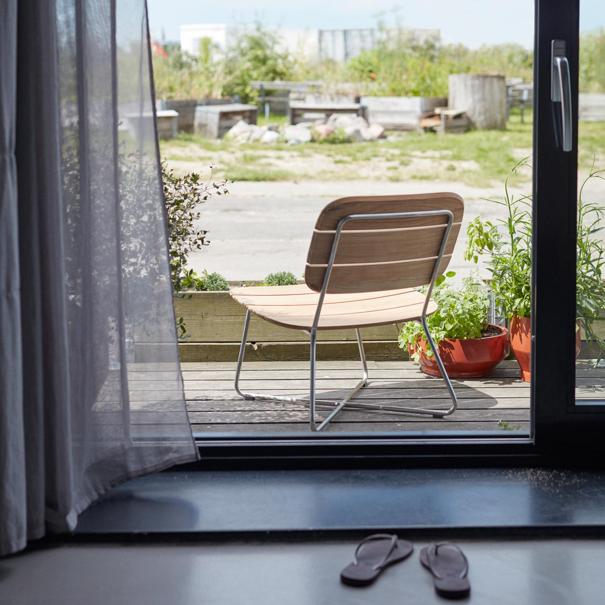 Lilium Teak Lounge Chair by Skagerak, showing Lilium teak lounge chair in live shot.