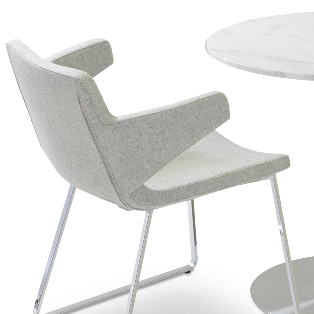 Nevada Sled Arm Chair by SohoConcept, showing closeup view of nevada sled arm chair in camira blazer silver wool with table.