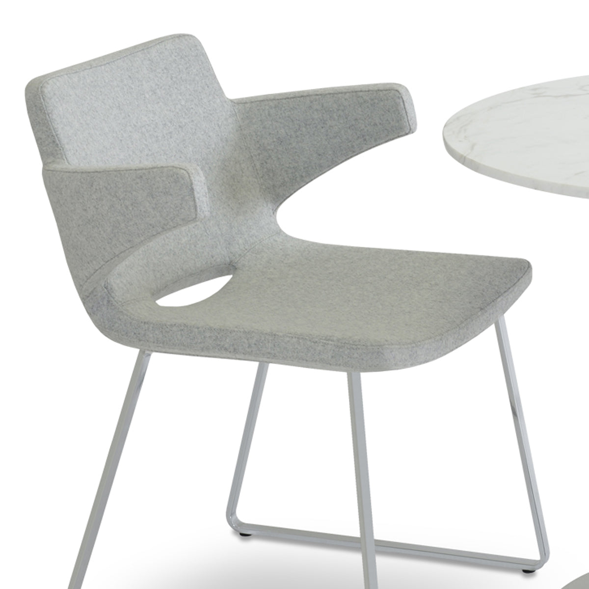 Nevada Sled Arm Chair by SohoConcept, showing closeup view of nevada sled arm chair in camira blazer silver wool with table.