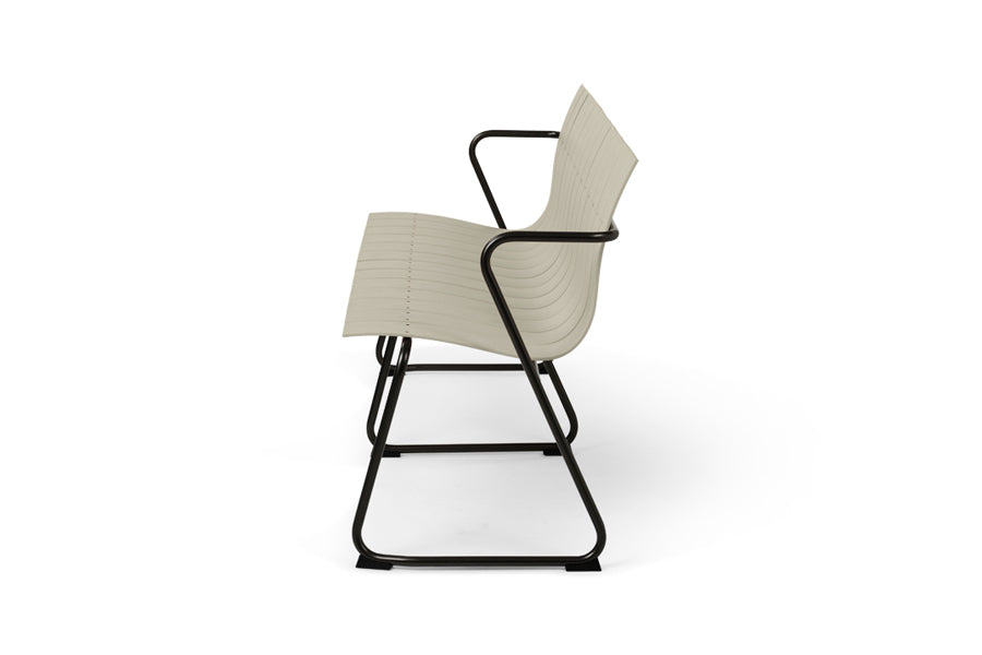 Ocean Bench by Mater, showing side view of ocean bench in sand plastic seat.