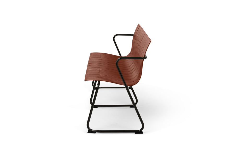 Ocean Bench by Mater, showing side view of ocean bench in burnt red plastic seat.