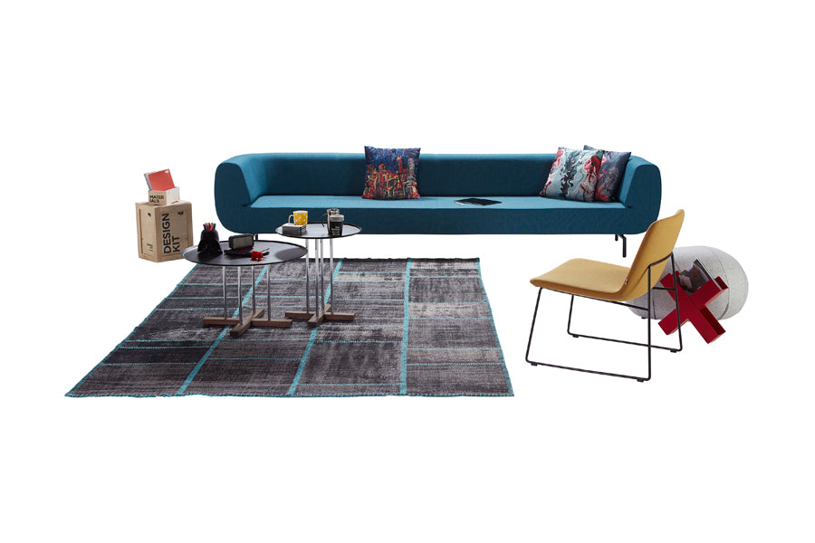 Pera Sled Lounge Chair by B&T, showing back view of pera sled lounge chair in black base with sofa & side tables.