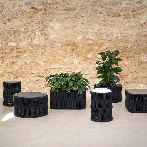 Weave Ottoman by Point, showing weave ottoman with planters in live shot.