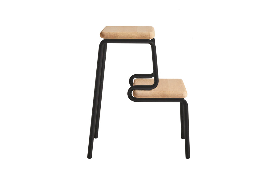 Slalom Step Stool by Woud, showing side view of slalom step stool in white pigmented lacquered oak with black painted legs.