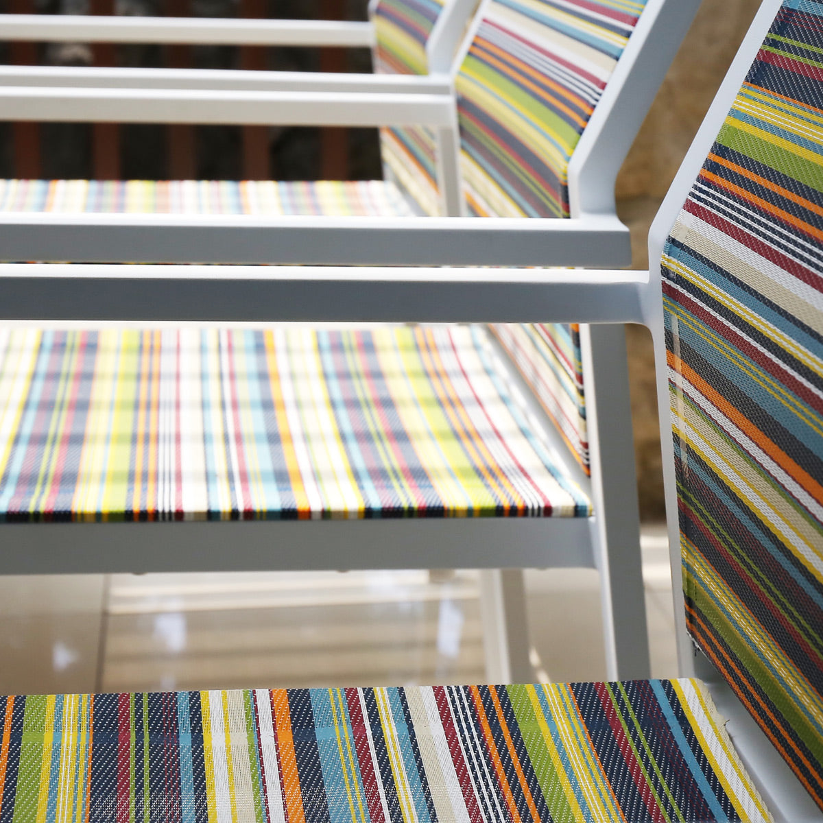 Stripe Stackable Armchair by Mamagreen, showing closeup view of stripe stackable armchairs in live shot.