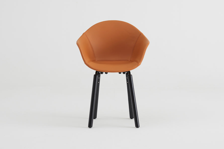 TA Upholstered Armchair by Toou, showing front view of ta upholstered armchair yi in black/black oak base/cognac pu shell seat.