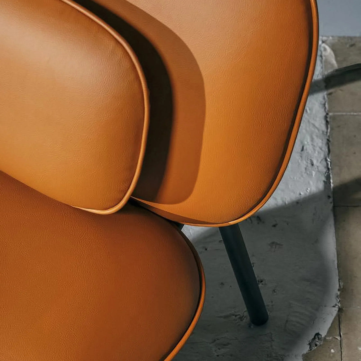 Tasca Pillow by Toou, showing closeup view of tasca pillow with lounge chair in live shot.