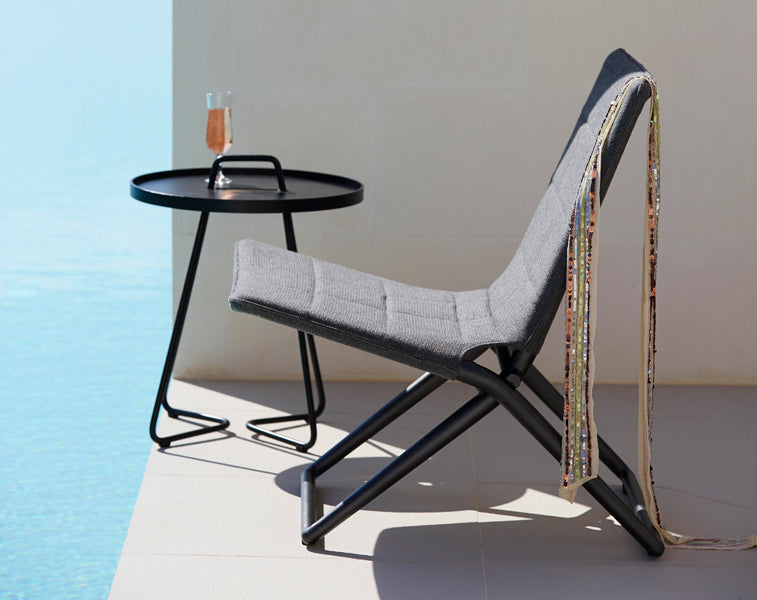 Traveller Lounge Folding Chair by Cane-Line, showing traveller lounge folding chair in live shot.