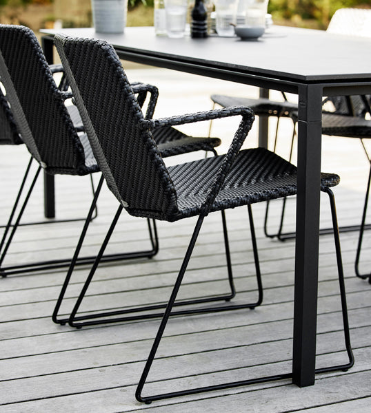 Vision Stackable Armchair by Cane-Line, showing closeup view of vision stackable armchairs in live shot.