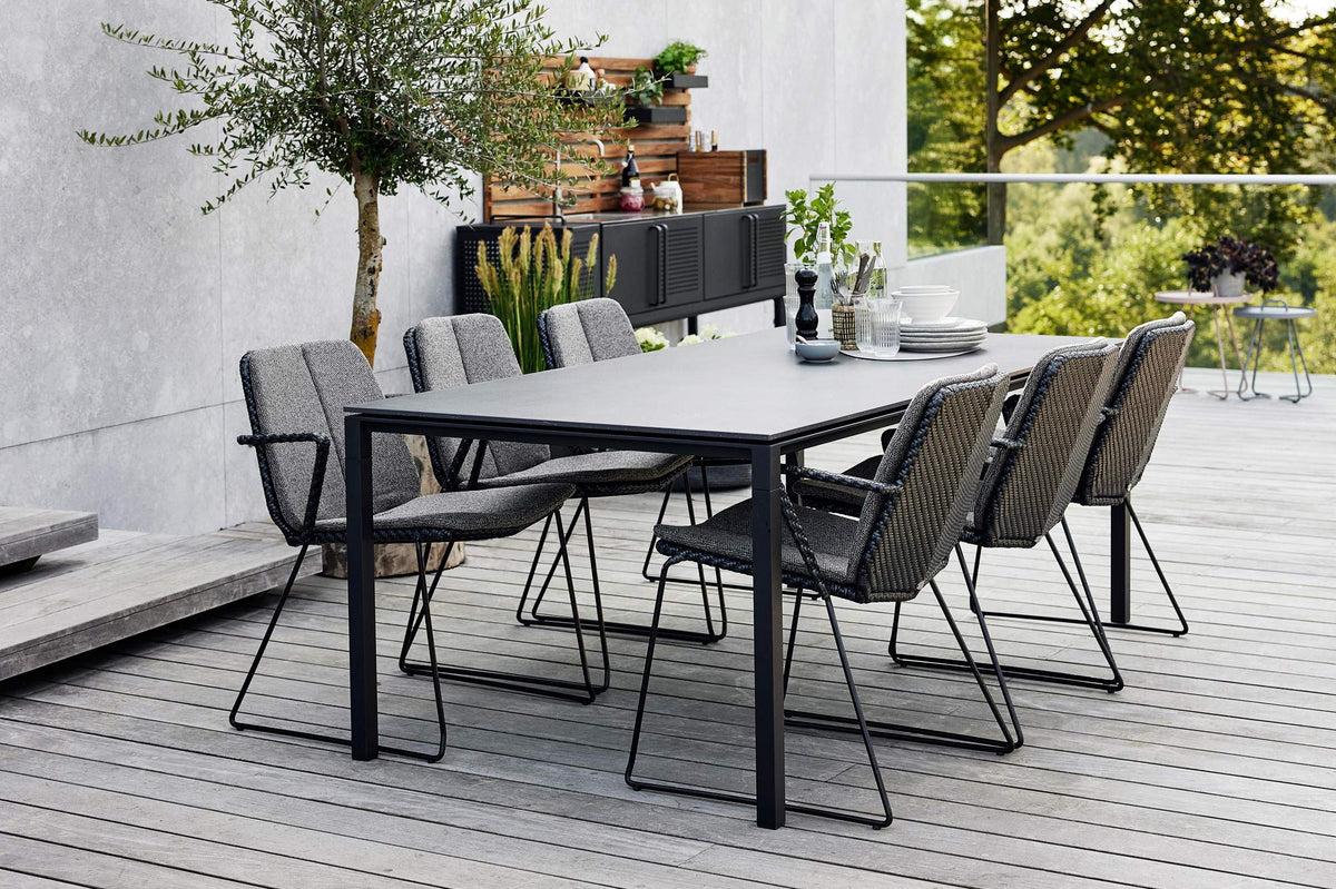 Vision Stackable Armchair by Cane-Line, showing vision stackable armchairs in live shot.