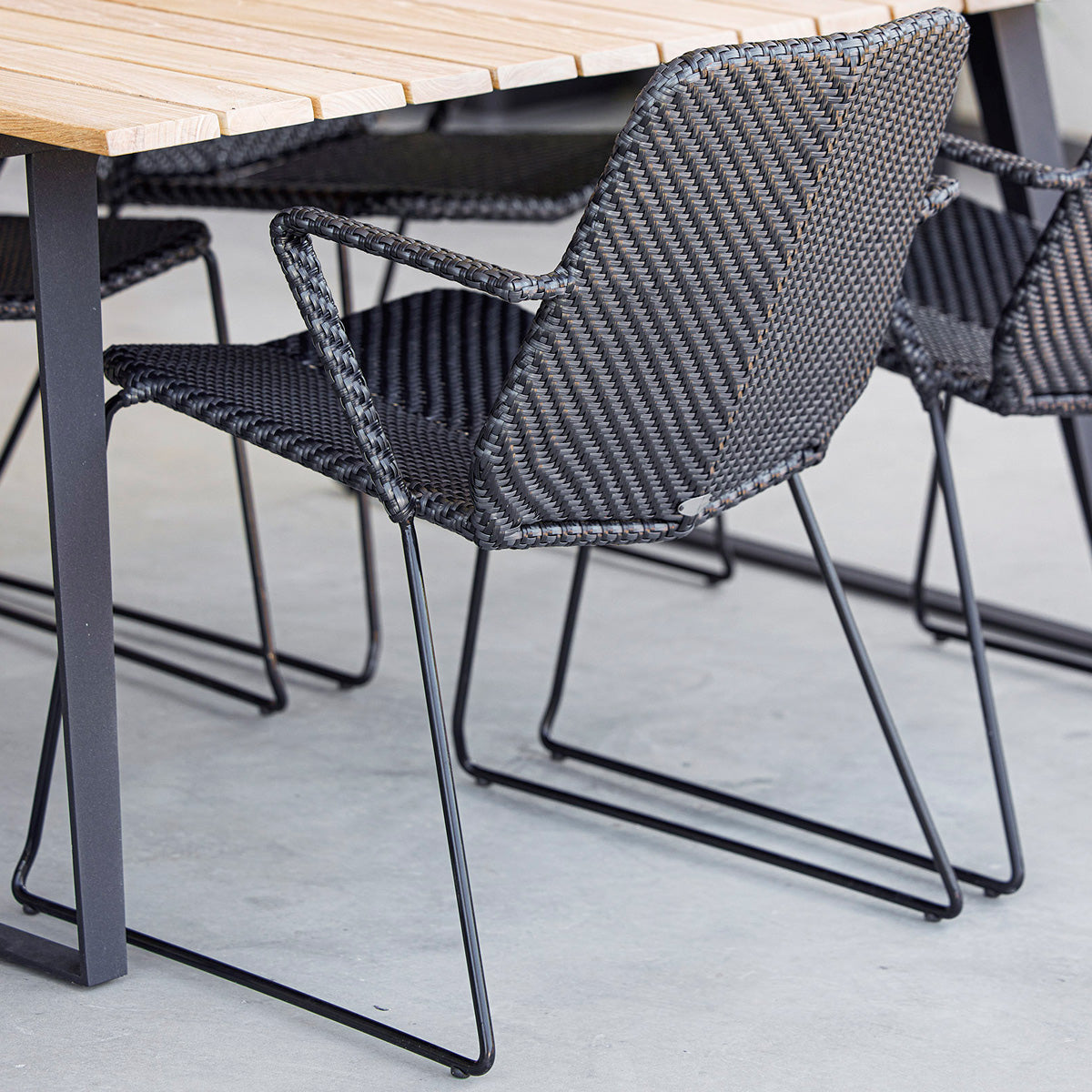 Vision Stackable Armchair by Cane-Line, showing closeup view of vision stackable armchairs in live shot.