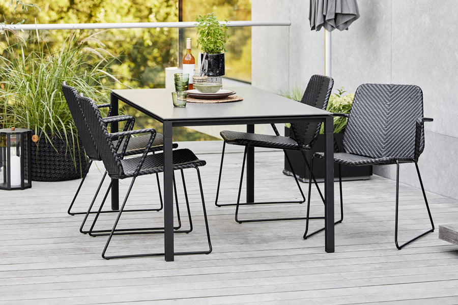Vision Stackable Armchair by Cane-Line, showing vision stackable armchairs in live shot.