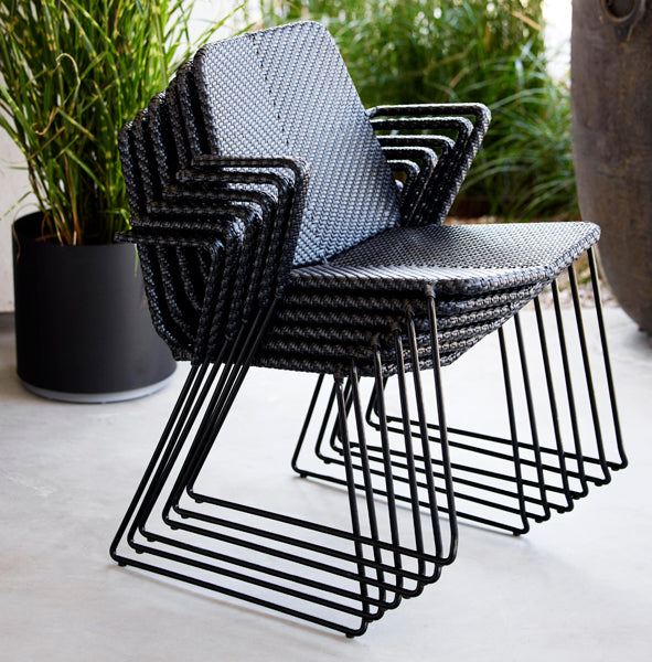 Vision Stackable Armchair by Cane-Line, showing vision stackable armchairs in live shot.