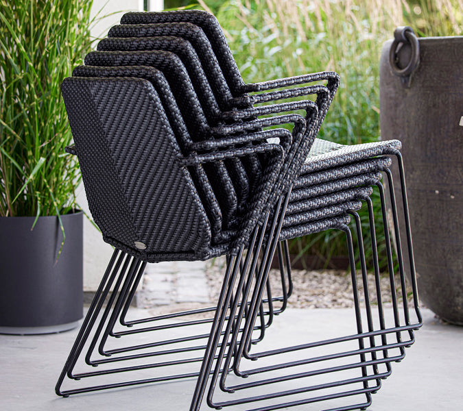 Vision Stackable Armchair by Cane-Line, showing vision stackable armchairs in live shot.