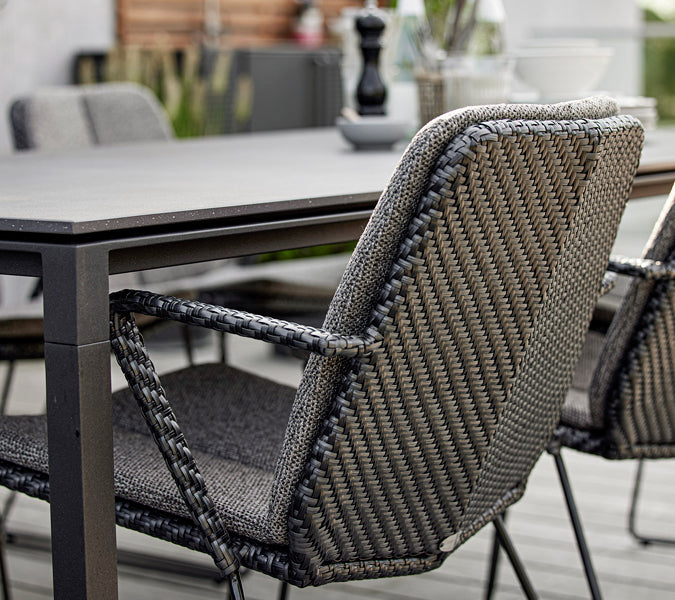 Vision Stackable Armchair by Cane-Line, showing closeup view of vision stackable armchairs in live shot.
