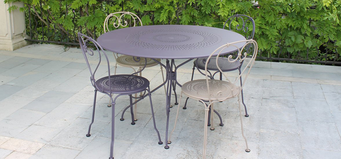 1900 Stacking Chair by Fermob, showing angle view of chairs with table in the live shot.