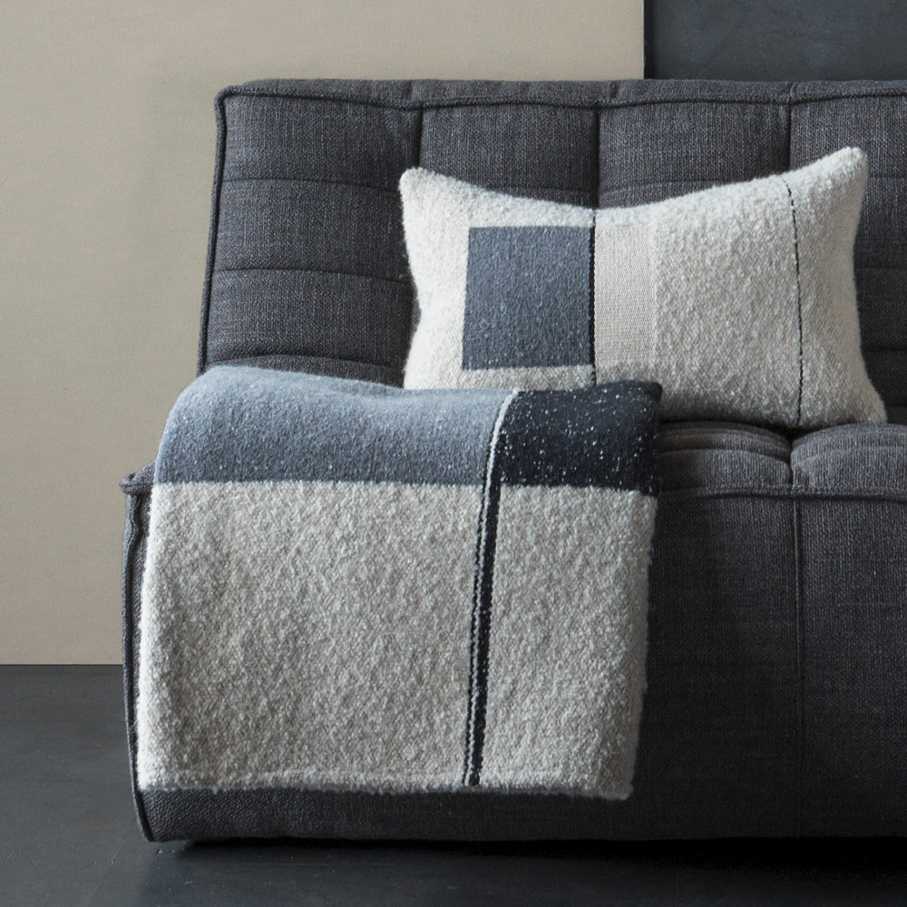 Urban Throw by Ethnicraft, showing throw with cushion in live shot.