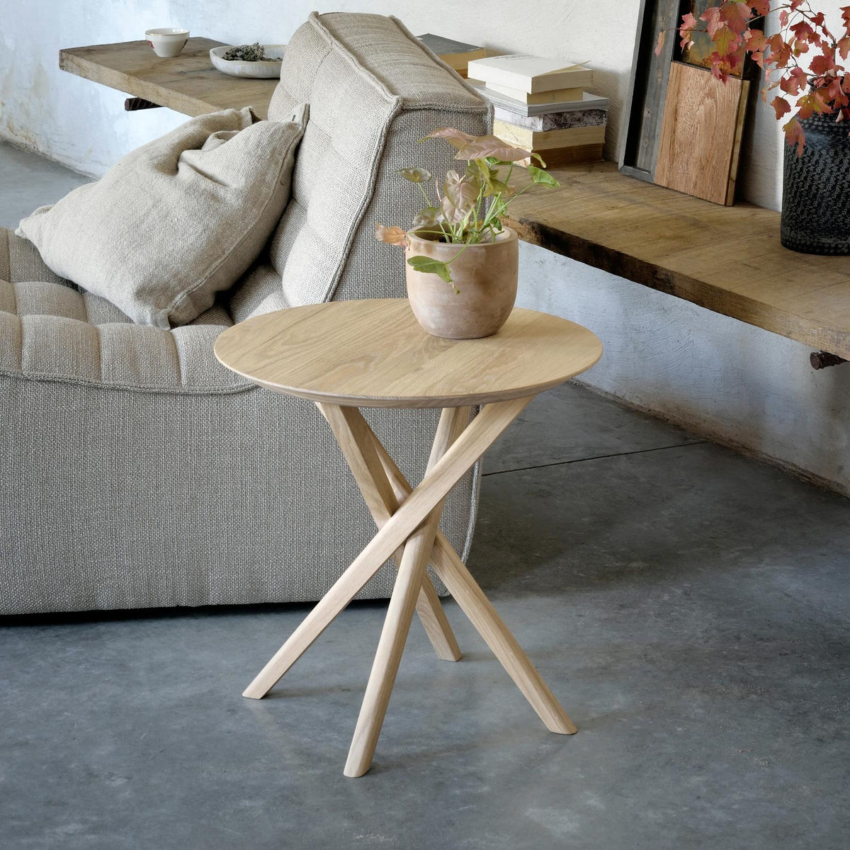 Mikado Side Table by Ethnicraft, showing front view of side table with sofa in the live shot.